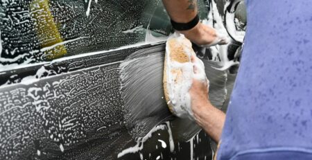 a man washing a car with a sponge